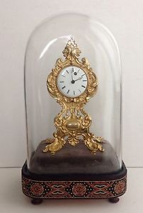 Gilded pendulette with verge fusee movement under glass dome.